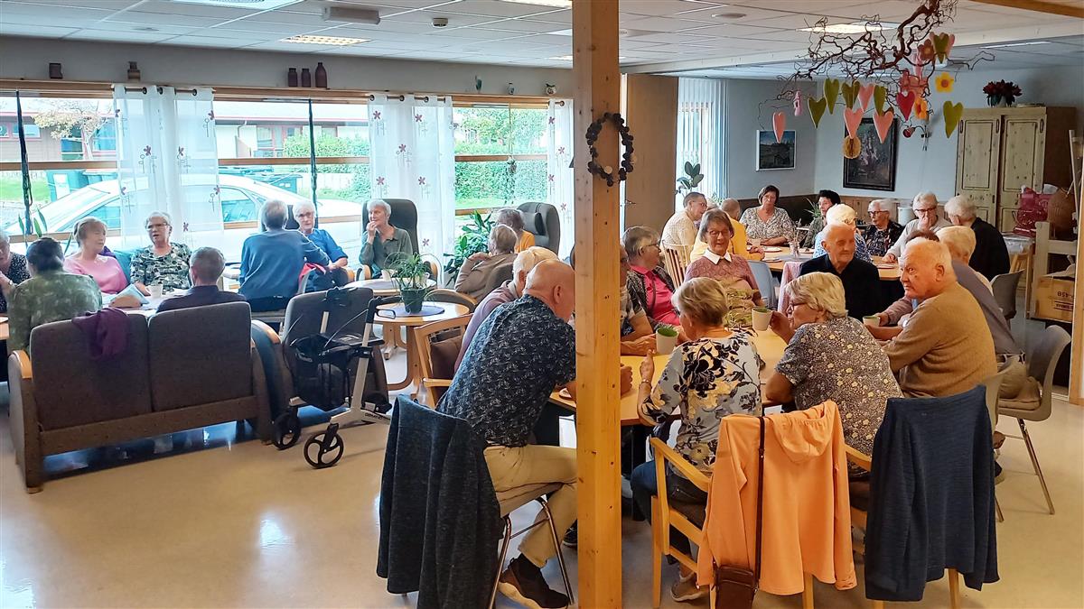 Eldre personer rundt småbord. - Klikk for stort bilde