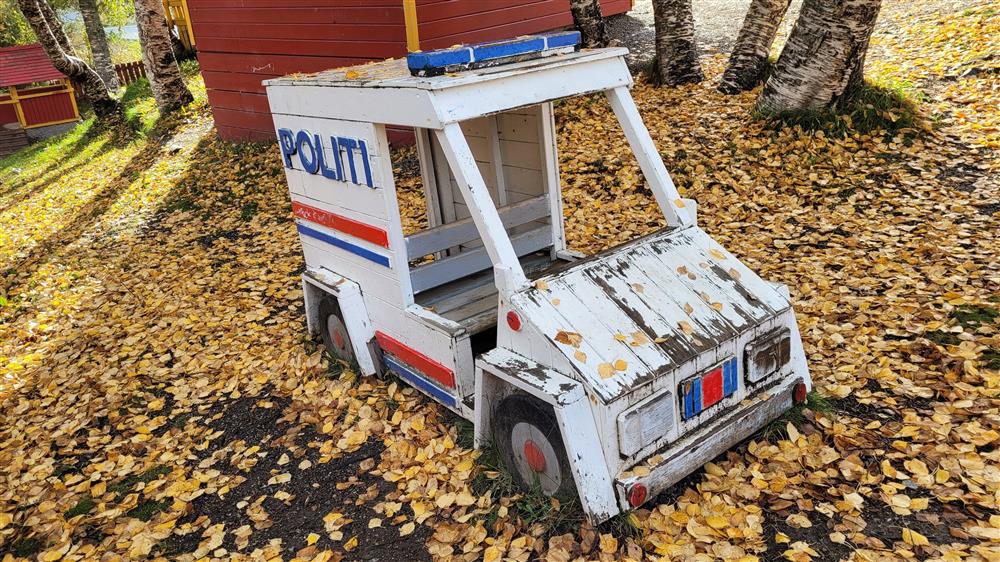 Politi-lekebil man kan sitte inni, ute på leikeplass. Foto. - Klikk for stort bilde